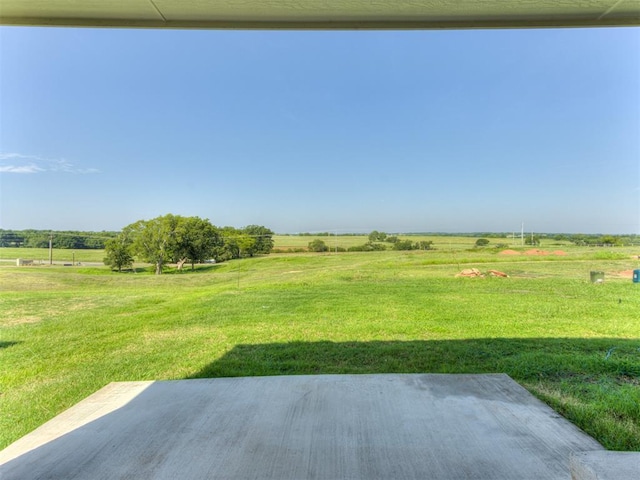 view of yard with a rural view and a patio area