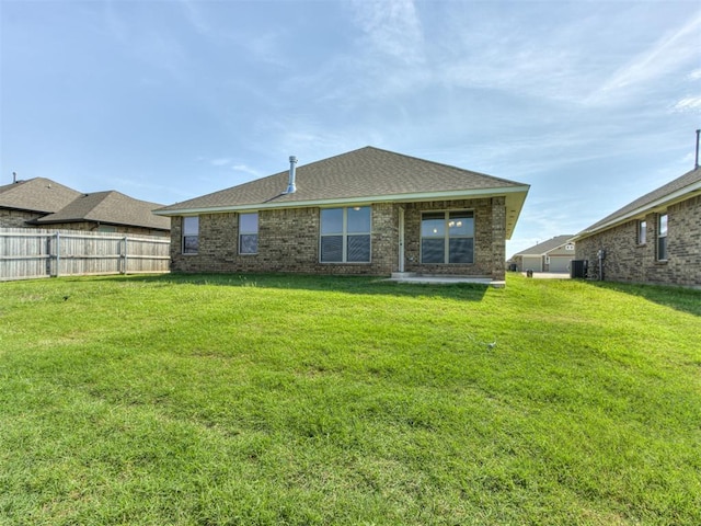 back of house with a lawn and central AC unit