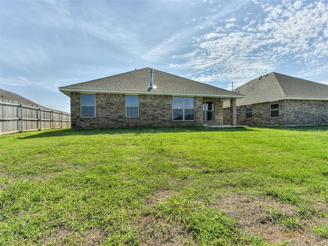 rear view of house featuring a lawn