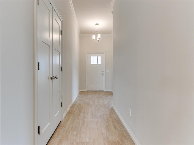 doorway featuring crown molding and a notable chandelier