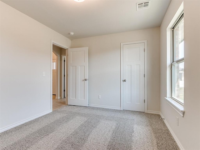 unfurnished bedroom featuring light carpet