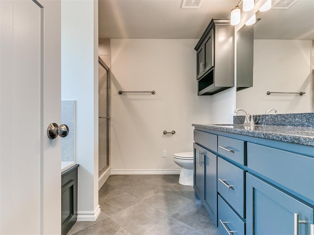 bathroom with vanity, toilet, and a shower with door