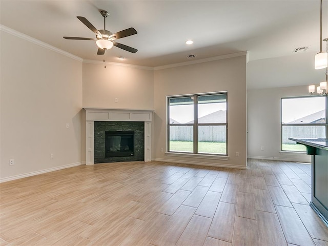 unfurnished living room with a tile fireplace, light wood-type flooring, a wealth of natural light, and ceiling fan