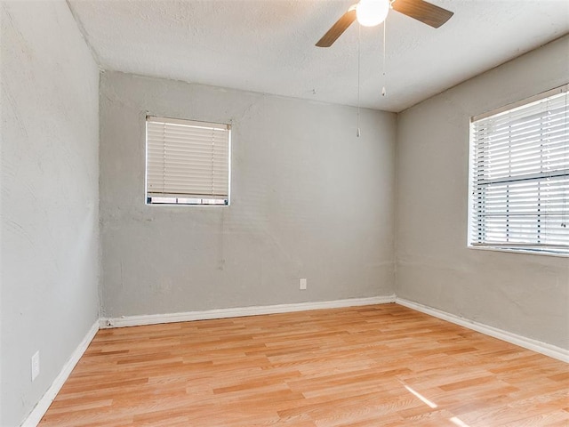 unfurnished room with ceiling fan, light hardwood / wood-style flooring, and a textured ceiling