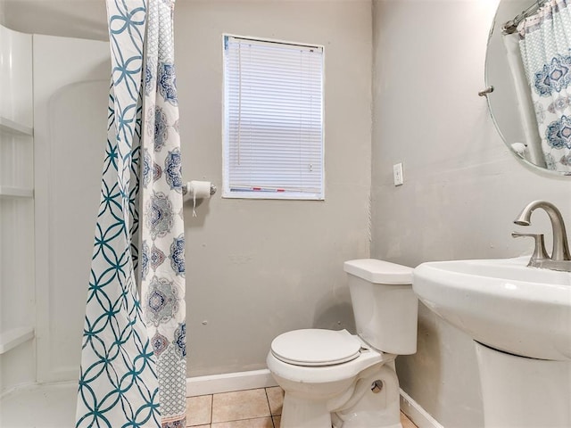 bathroom with tile patterned flooring, sink, toilet, and walk in shower