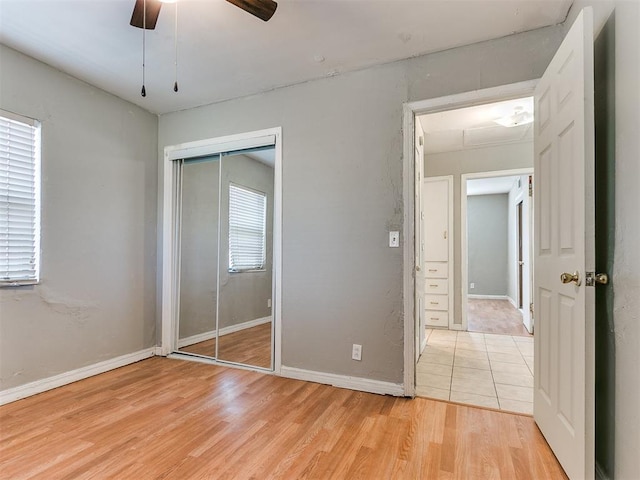 unfurnished bedroom featuring light wood-type flooring, a closet, and ceiling fan