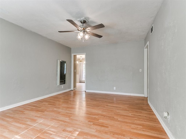 empty room with ceiling fan and light hardwood / wood-style floors