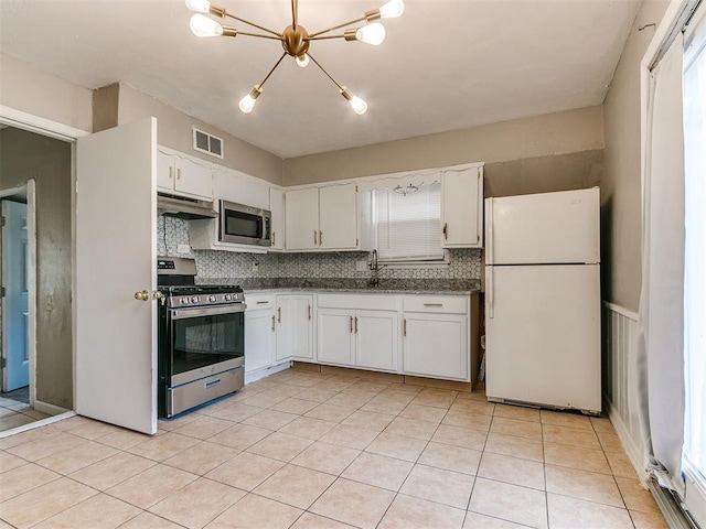 kitchen with white cabinetry, backsplash, appliances with stainless steel finishes, and a chandelier