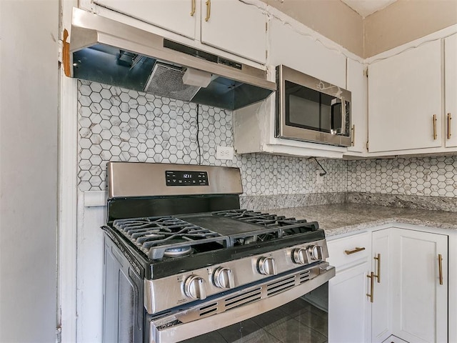 kitchen with white cabinets, appliances with stainless steel finishes, and tasteful backsplash