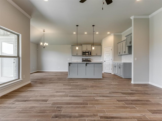 kitchen featuring gray cabinets, a healthy amount of sunlight, decorative light fixtures, and appliances with stainless steel finishes