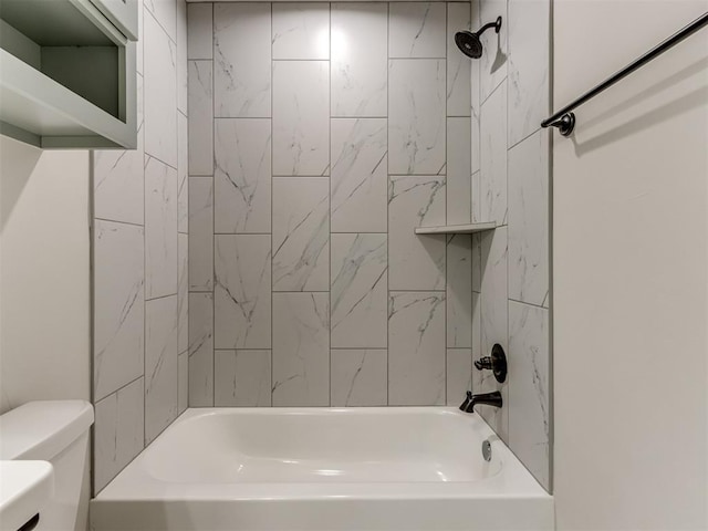 bathroom featuring toilet and tiled shower / bath