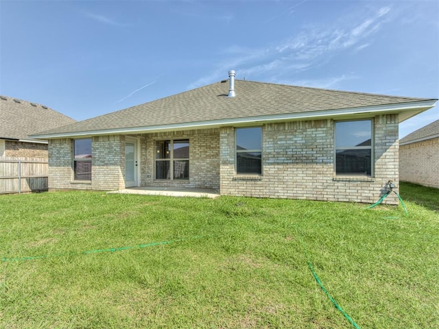 rear view of house featuring a yard and a patio