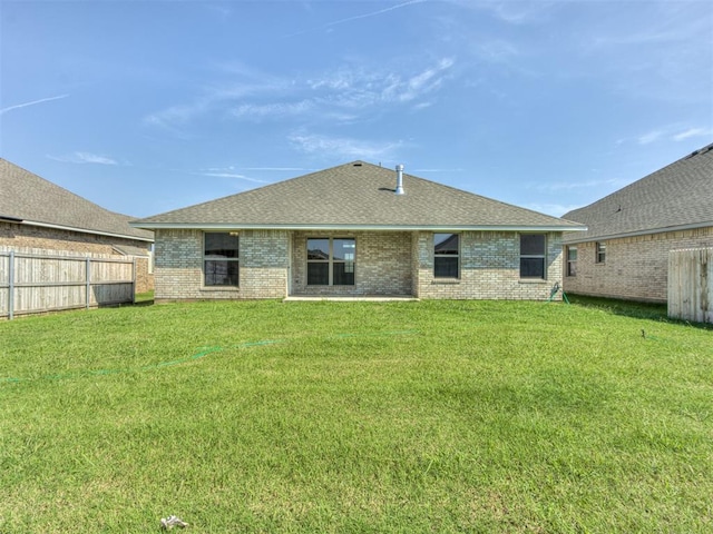 rear view of property with a yard