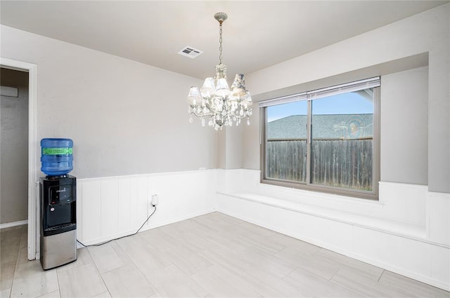 unfurnished room with a notable chandelier