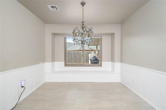 unfurnished dining area featuring a notable chandelier