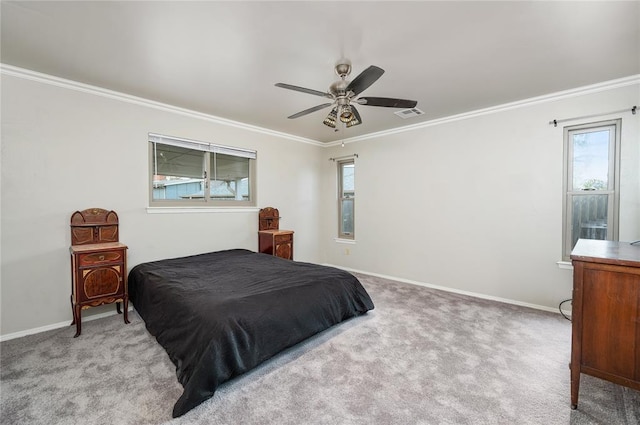 carpeted bedroom with ceiling fan and ornamental molding