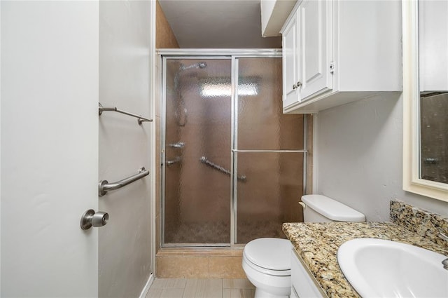 bathroom with tile patterned floors, vanity, toilet, and an enclosed shower