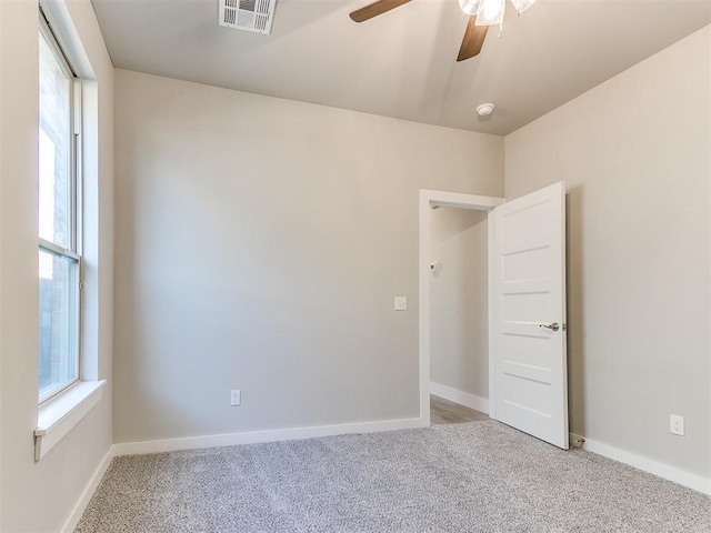 carpeted spare room with ceiling fan