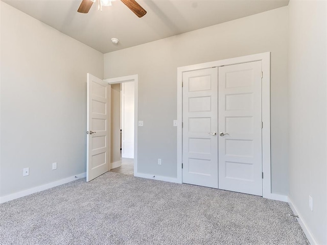 unfurnished bedroom featuring ceiling fan, a closet, and light carpet