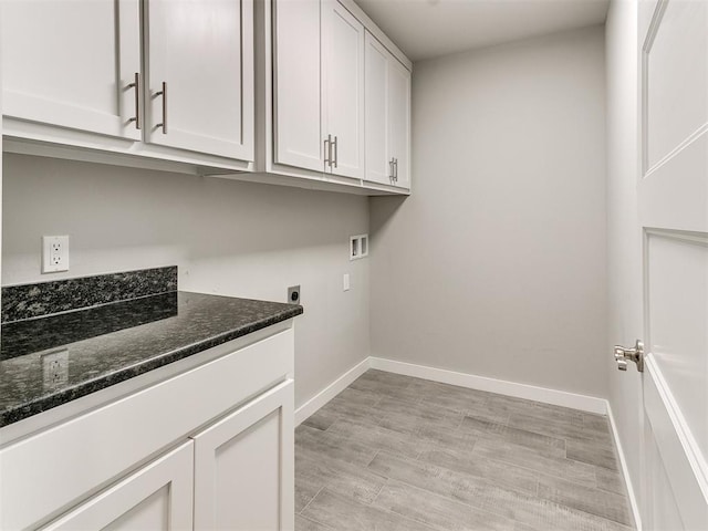 clothes washing area featuring electric dryer hookup, cabinets, hookup for a washing machine, and light hardwood / wood-style floors