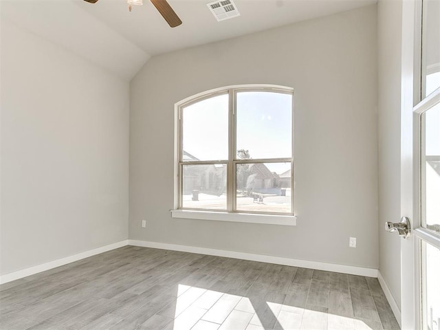 spare room with lofted ceiling and light hardwood / wood-style flooring