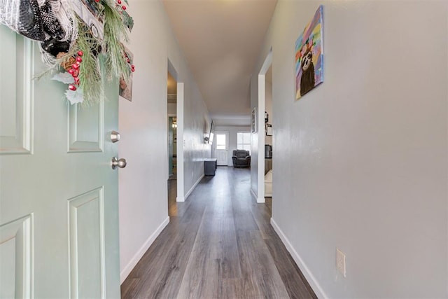 corridor with wood finished floors and baseboards