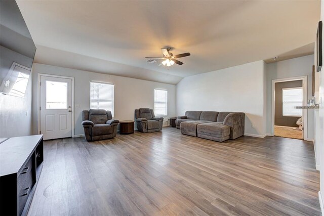 living room featuring baseboards, visible vents, a ceiling fan, wood finished floors, and vaulted ceiling