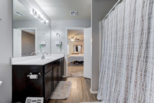 full bathroom featuring vanity, wood finished floors, visible vents, and a ceiling fan