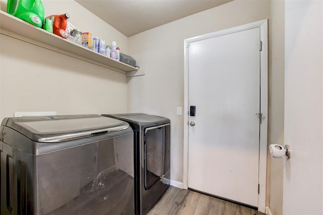 laundry area with washer and dryer, laundry area, baseboards, and wood finished floors