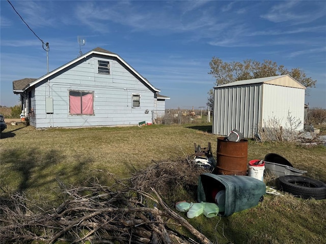 view of side of home featuring a yard and a shed