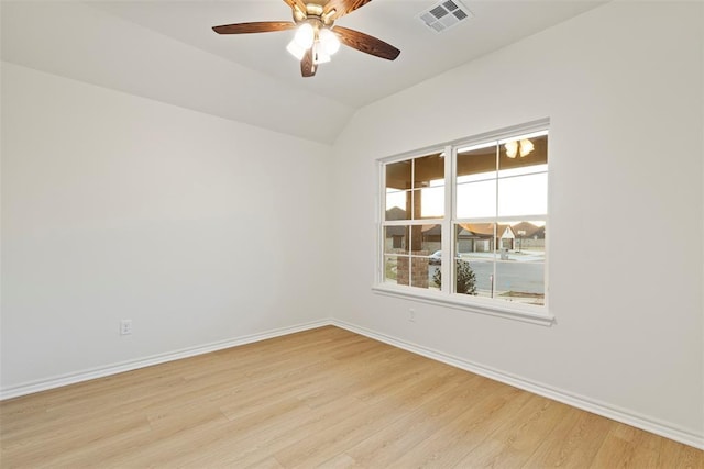 empty room with ceiling fan, light hardwood / wood-style floors, and vaulted ceiling