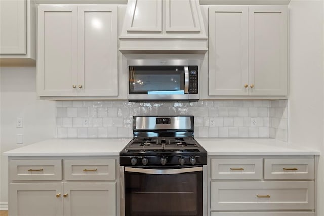 kitchen with white cabinetry, appliances with stainless steel finishes, and tasteful backsplash