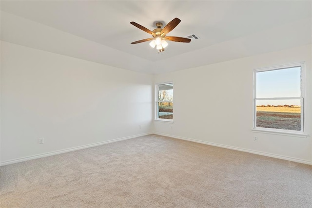 empty room featuring light carpet, ceiling fan, and a healthy amount of sunlight