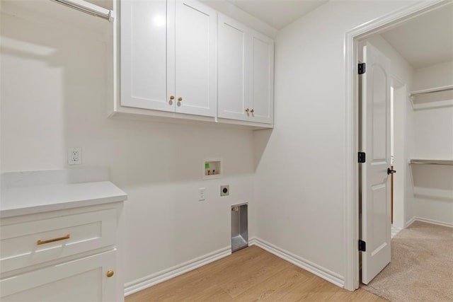 washroom with hookup for an electric dryer, hookup for a washing machine, light hardwood / wood-style flooring, and cabinets