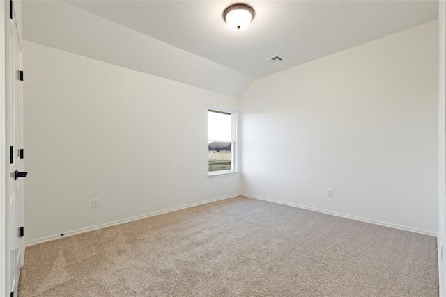 carpeted spare room featuring lofted ceiling