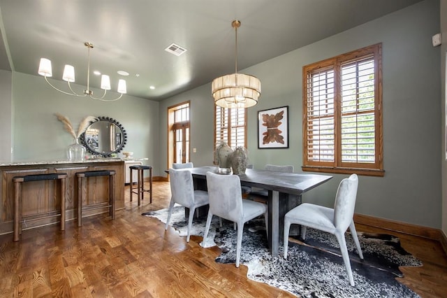 dining room featuring a notable chandelier and dark wood-type flooring