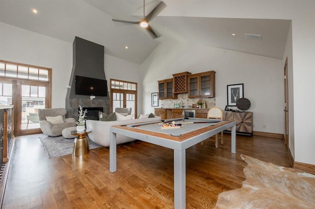 playroom featuring a tile fireplace, indoor bar, hardwood / wood-style flooring, high vaulted ceiling, and pool table