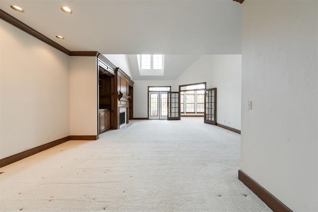 unfurnished living room with lofted ceiling, light colored carpet, and crown molding