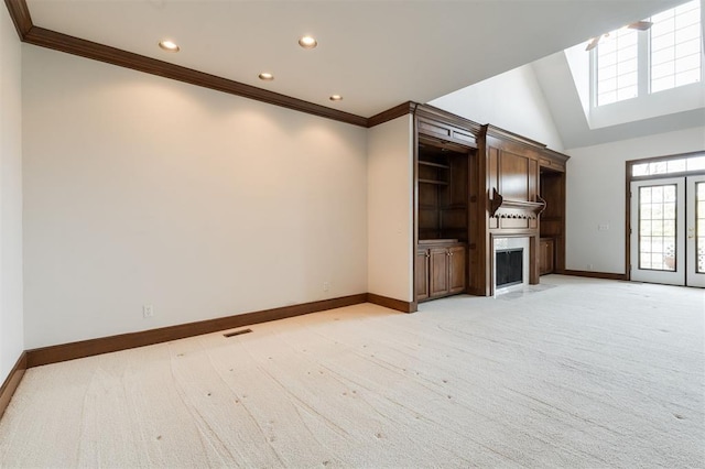 unfurnished living room featuring a large fireplace, light colored carpet, lofted ceiling, and crown molding