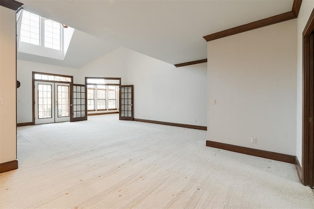 carpeted spare room featuring french doors, high vaulted ceiling, and crown molding