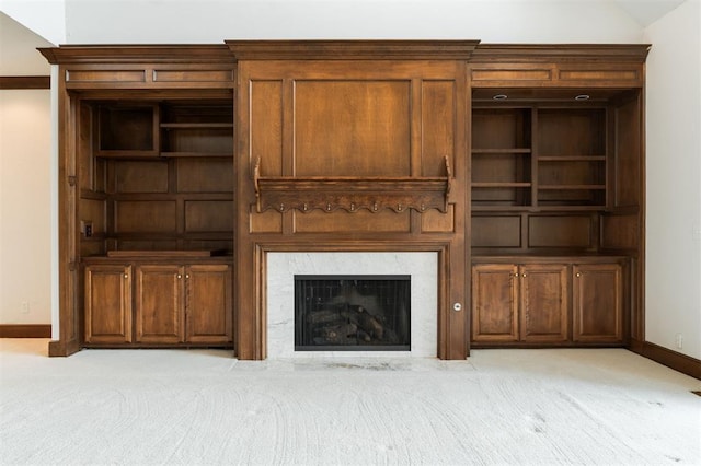 unfurnished living room with vaulted ceiling, light colored carpet, and a tiled fireplace