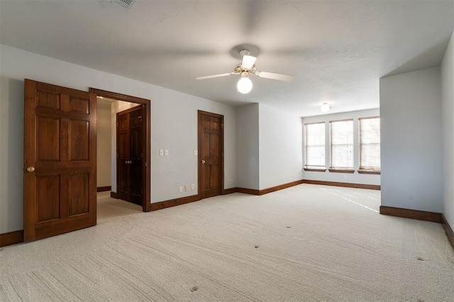 empty room with ceiling fan and light carpet