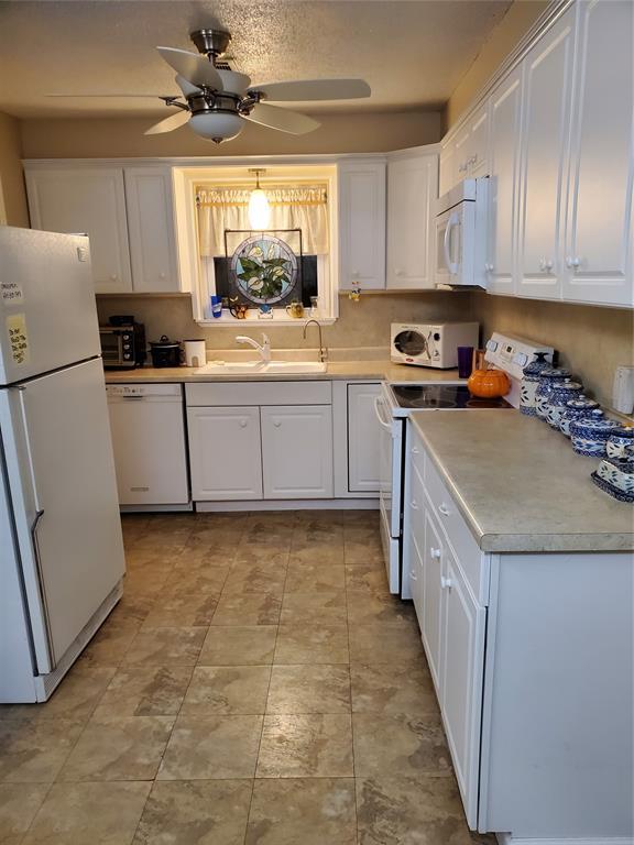 kitchen featuring white cabinets, ceiling fan, white appliances, and sink