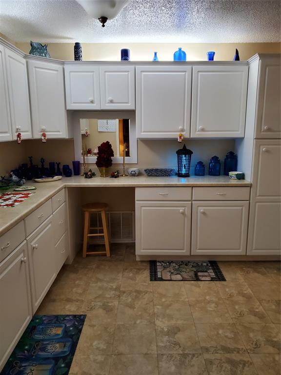 kitchen featuring white cabinetry and a textured ceiling