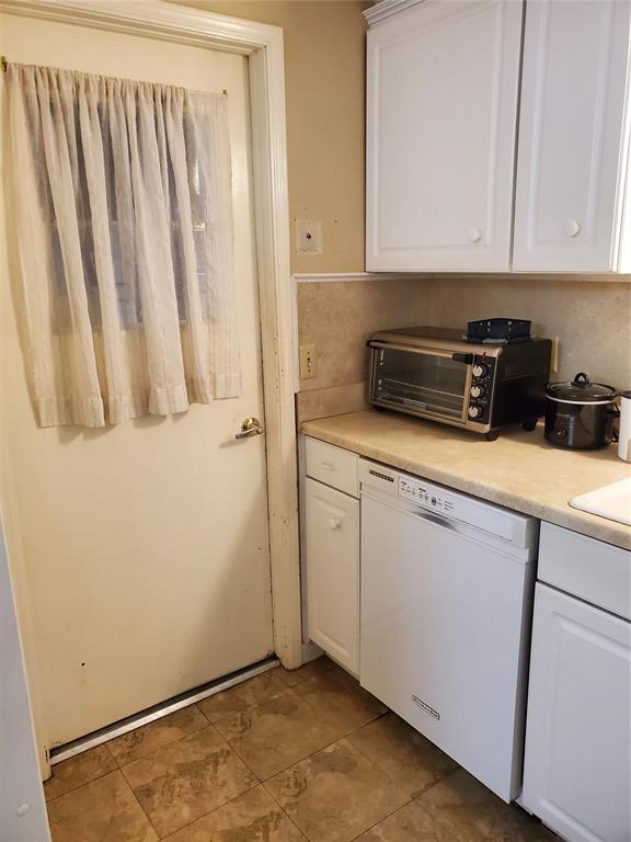 kitchen featuring decorative backsplash, white cabinetry, and white dishwasher