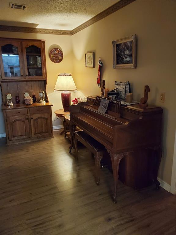 miscellaneous room with a textured ceiling and dark wood-type flooring