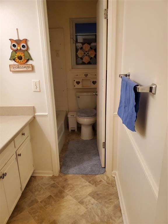 bathroom with a bathing tub, vanity, and toilet