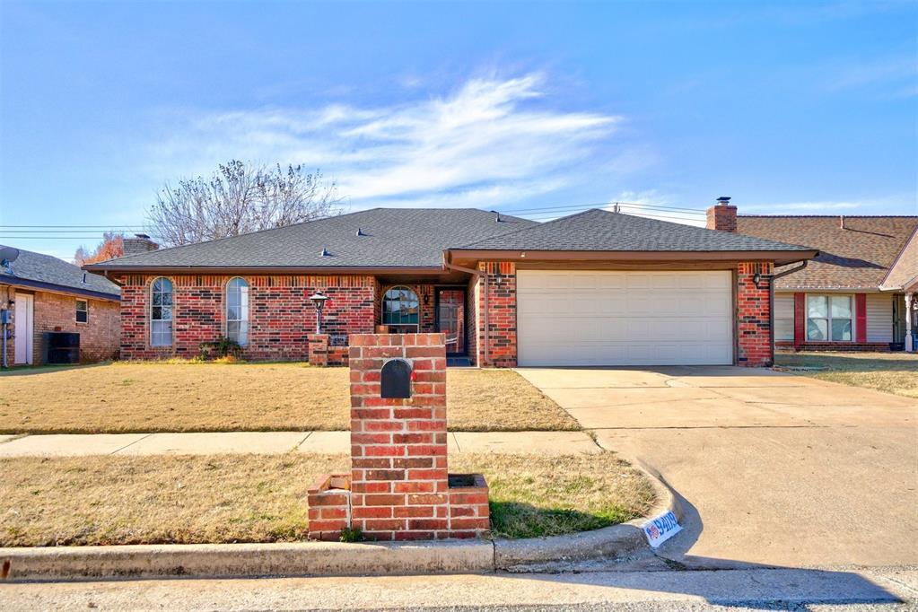 ranch-style home featuring a front yard, a garage, and central air condition unit