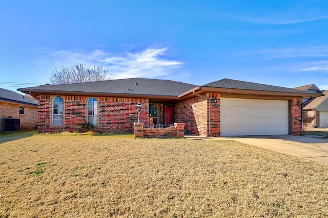 ranch-style home with a front lawn, cooling unit, and a garage