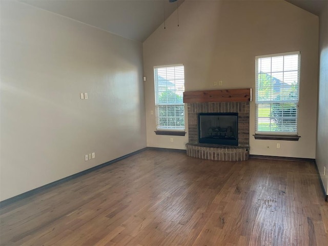 unfurnished living room featuring hardwood / wood-style floors, plenty of natural light, and high vaulted ceiling